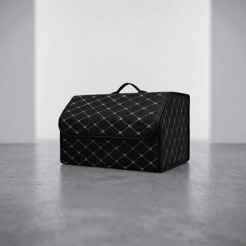 A single Matrikar trunk organizer in Black with White Stitching, large size, on a studio floor