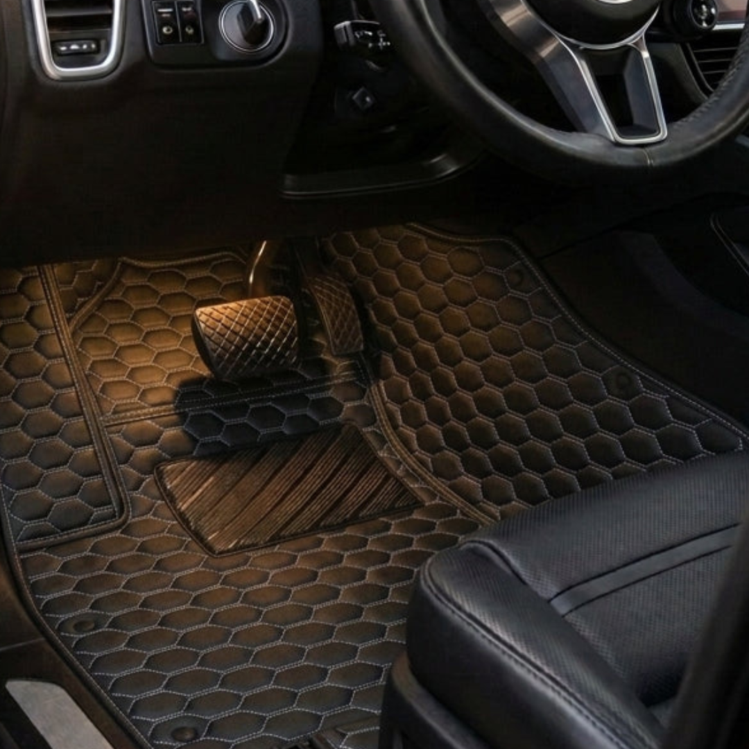 Matrikar Hexa Series custom fit car mat in Black with white stitching, installed in a driver footwell